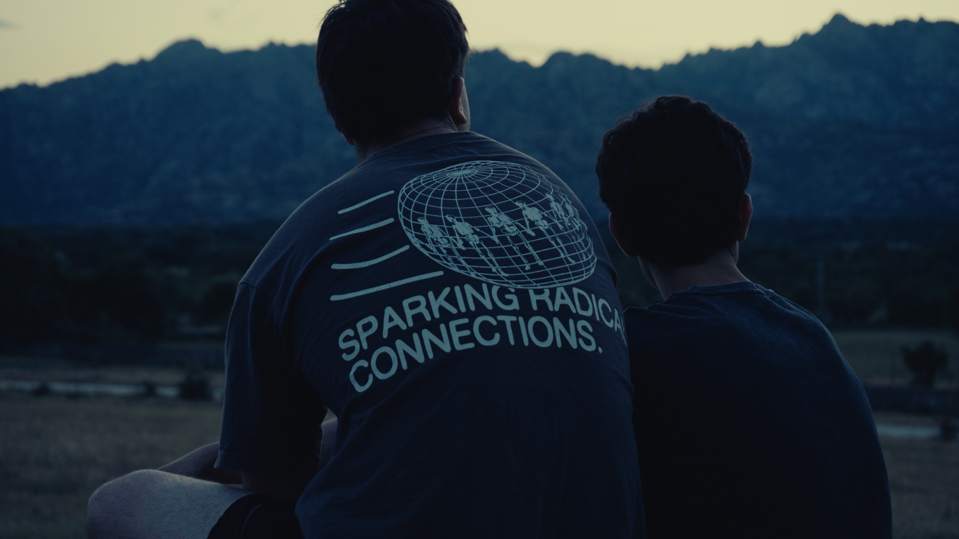 Dos atletas de espaldas mirando la sierra al atardecer